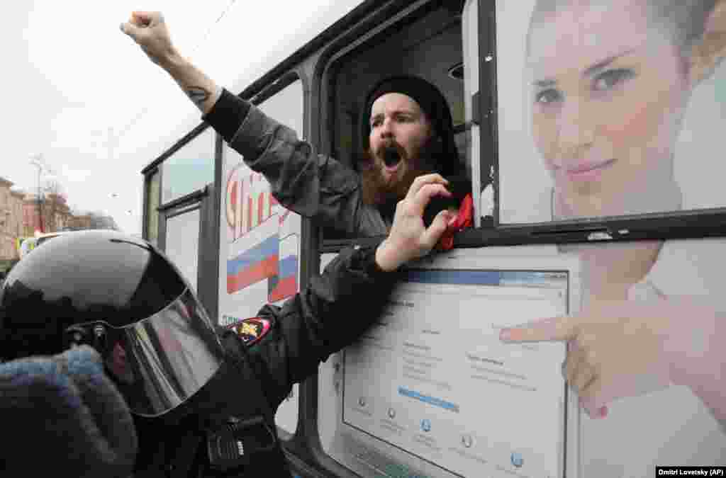 A detained member of the Other Russia movement shouts from a police bus during an unauthorized rally to mark the centenary of the Bolshevik Revolution in St. Petersburg on November 6. (AP/Dmitry Lovetsky)