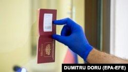 MOLDOVA -- A man shows his passport in a polling station at the Embassy of Russia in Moldova during voting in a referendum on amendments to the Russian Constitution in Chisinau, July 1, 2020. 