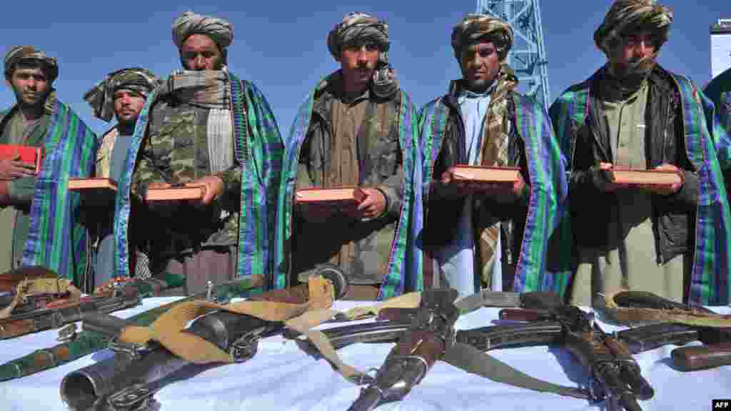 Former Taliban fighters display their weapons during a ceremony in Herat on October 22 after they joined the Afghan government forces. Afghanistan is bolstering its military in preparation for the withdrawal of foreign combat troops by the end of 2014. (AFP/Arif Karimi)