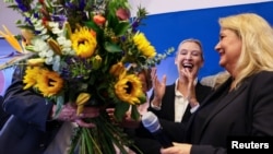 Співголова партії «Альтернатива для Німеччини» (AfD) Аліс Вайдель аплодує, коли провідна кандидатка від партії Крістін Брінкер отримує квіти. Берлін, Німеччина, 20 вересня 2026 року
