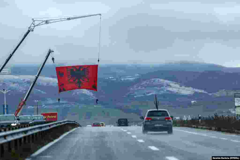 Një flamur kombëtar shqiptar i vendosur në një rrugë diku në Kosovë. 