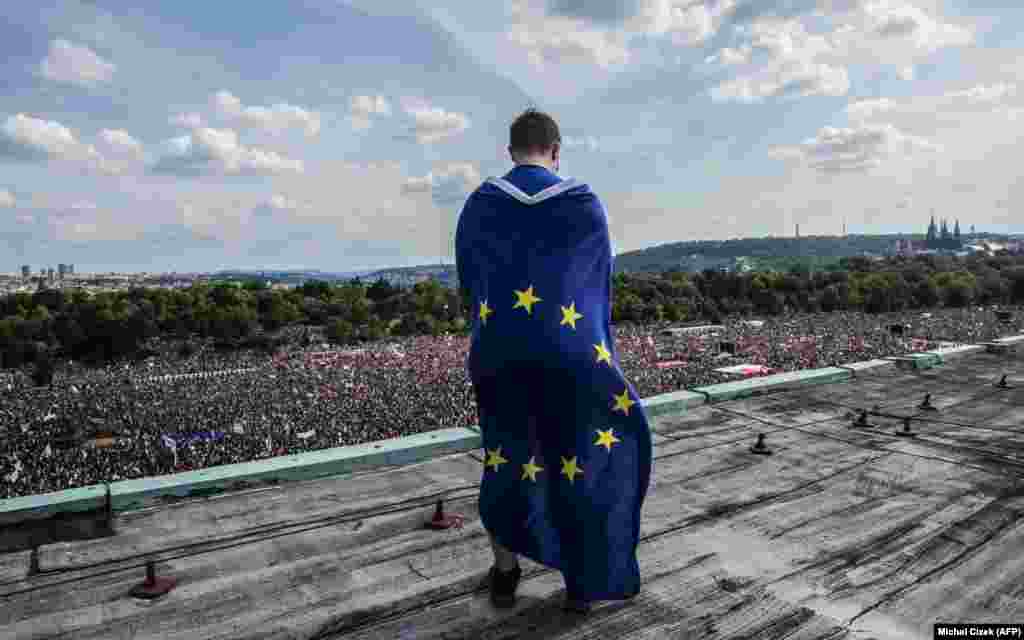 A man wrapped in a European flag observes a monster rally demanding the resignation of Czech Prime Minister Andrej Babis in Prague on June 23.&nbsp;