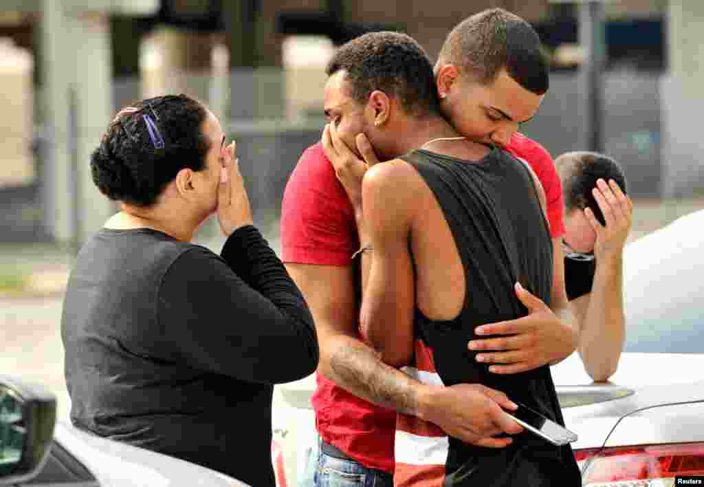 Friends and family members embrace outside Orlando police headquarters following the June 12 massacre at the Pulse nightclub, where 49 people were shot and killed by Omar Mateen, a U.S.-born citizen of Afghan descent. Police said the attacker opened fire with an AR-15 assault rifle and a handgun in the nightclub shortly before 2 a.m. and then held a group of club patrons hostage for three hours before he was killed in a shoot-out. (Reuters/Steve Nesius) 