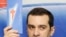 Georgia's Irakli Alasania holds up a leaflet at a July 16 press conference to introduce his new party, Our Georgia--Free Democrats