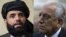 A combo photo shows U.S. peace envoy Zalmay Khalilzad (right) and Suhail Shaheen, spokesman for the Taliban's political office in Doha