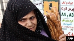 Женщина несет в руках традиционный иранский хлеб Барбари. Тегеран, 16 августа 2010 года.