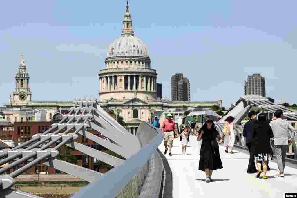 Žena sa suncobranom na Milenijum mostu u Londonu, 23. juni 2026.
