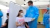 România: vaccinarea tinerilor de la 12 ani. Ana, în vârstă de 14 ani primește o diplomă de vaccinare anti Covid-19 de la șeful campaniei naționale de vaccinare, Valeriu Gheorghiță. 