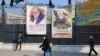 IRAN -- Iranians walk past a poster depicting late Revolutionary Guards commander Qasem Soleimani (R) and nuclear scientist Mohsen Fakhrizadeh, assassinated last month, in the capital Tehran, December 30, 2020