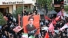Crowds of mourners gather around a portrait of Iran's supreme leader, Mojtaba Khamenei, ahead of the funeral procession for his slain father earlier this month. A statement was issued in his name on July 18, although he hasn't been seen in public since at least February 28.