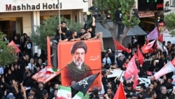 Crowds of mourners gather around a portrait of Iran's supreme leader, Mojtaba Khamenei, ahead of the funeral procession for his slain father earlier this month. A statement was issued in his name on July 18, although he hasn't been seen in public since at least February 28.