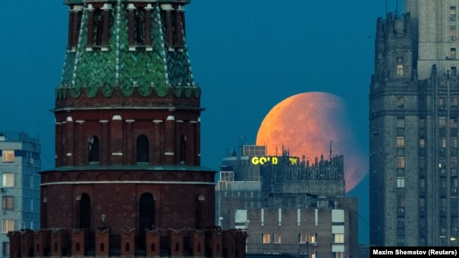 Russia - Partial lunar eclipse is seen over the Kremlin and Russia's Foreign Ministry headquarters building in Moscow, September 18, 2024.