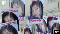 Pakistani protesters carry photographs of Aafia Siddiqui during a march to support her in Karachi on September 23.