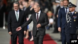 Cancelarul german Olaf Scholz (dreapta) îi arată calea premierului laburist britanic Keir Starmer, la sosirea în vizită la cancelaria federală de la Berlin, pe 28 august 2024. 