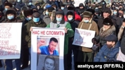 Наразылыққа шыққандардың бірі "Назарбаев - диктатор" деген плакат ұстап тұр.