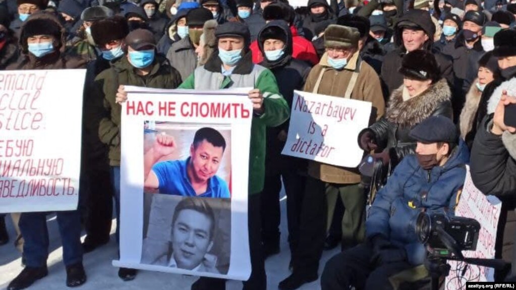 На митинге в Уральске протестующий держит плакат "Назарбаев - диктатор". 28 февраля 2021 года.
