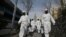 SOUTH KOREA -- South Korean soldiers wearing protective gear spray disinfectant on the street to help prevent the spread of the COVID-19 coronavirus, at a residential area in Seoul on March 9, 2020. 