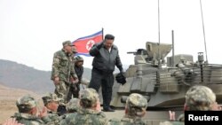Lideri i Koresë së Veriut, Kim Jong Un, qëndron mbi një tank, gjatë vëzhgimit të stërvitjeve të trupave të tij në Korenë e Veriut, 13 mars 2024.