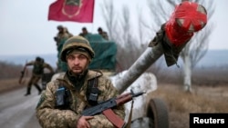 A serviceman stands guard as a Ukrainian Army convoy of heavy equipment prepares to pull back from the Debaltseve region on February 26. 