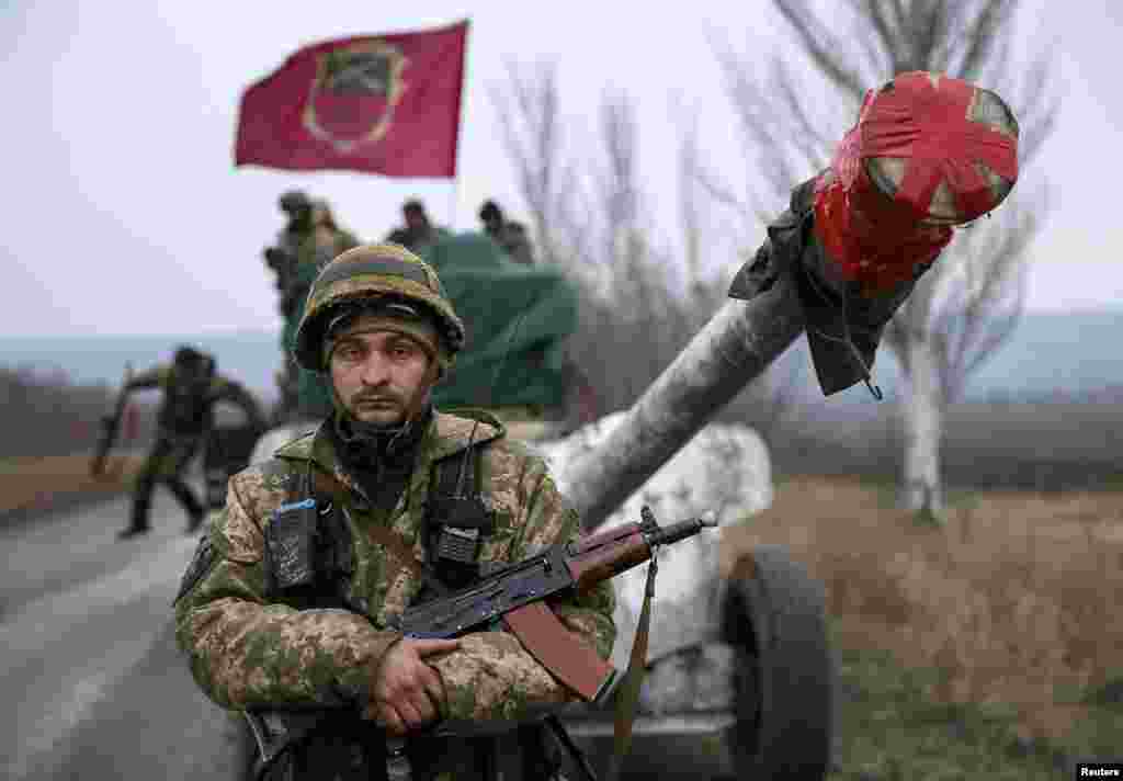 A member of the Ukrainian armed forces stands guard as a convoy of the Ukrainian armed forces prepare to move as they pull back from the Debaltseve region on February 26. Ukrainian troops towed artillery away from the front line, a move that amounted to recognizing that a cease-fire meant to take effect on February 15 appeared to be holding. (Reuters/Gleb Garanich)