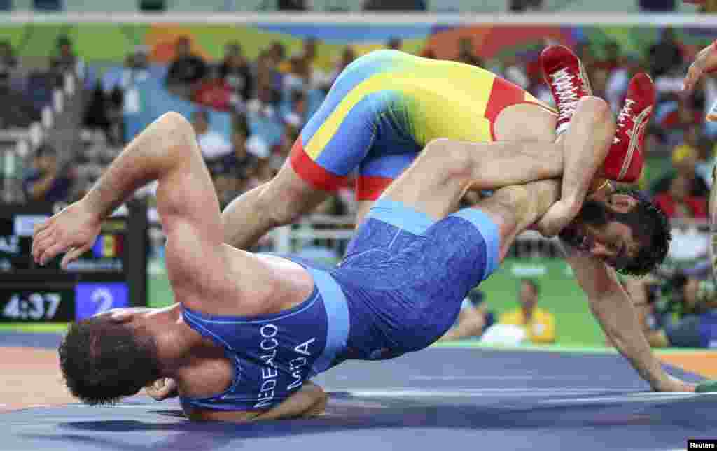 Wrestlers Galymzhan Usserbayev of Kazakhstan (top) and Evgheni Nedealco of Moldova compete in qualification for the men&#39;s freestyle 74-kilogram competition.&nbsp;