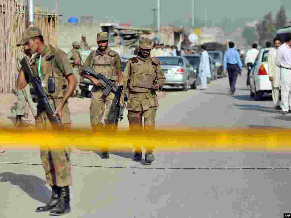 Pakistan -- Soldiers patrol the site of an attack on an army officer in Islamabad, 22Oct2009 - PAKISTAN, Islamabad : Pakistani soldiers patrol the site of an attack on an army officer in Islamabad on October 22, 2009. Gunmen riding a motorbike ambushed a military jeep in Pakistan's capital, unleashing a hail of bullets that killed a brigadier and his driver in a brazen daylight raid, officials said.