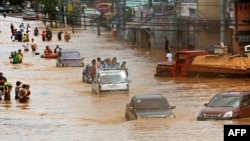 Motorists cross a flooded road in Marikina, east of Manila, on September 27.