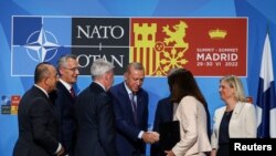 Predsednik Turske Redžep Tajip Erdogan se rukuje sa šeficom švedske diplomatije An Linde na samitu NATO-a u Madridu, 28. jun 2022.
