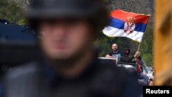 Protestuesit serbë duke valëvitur flamurin e Serbisë në Jarinjë. Shtator, 2021.