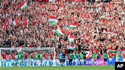 Hungary's players celebrate with fans after the Euro championship Group F match with France at Ferenc Puskas stadium in Budapest on June 19. 