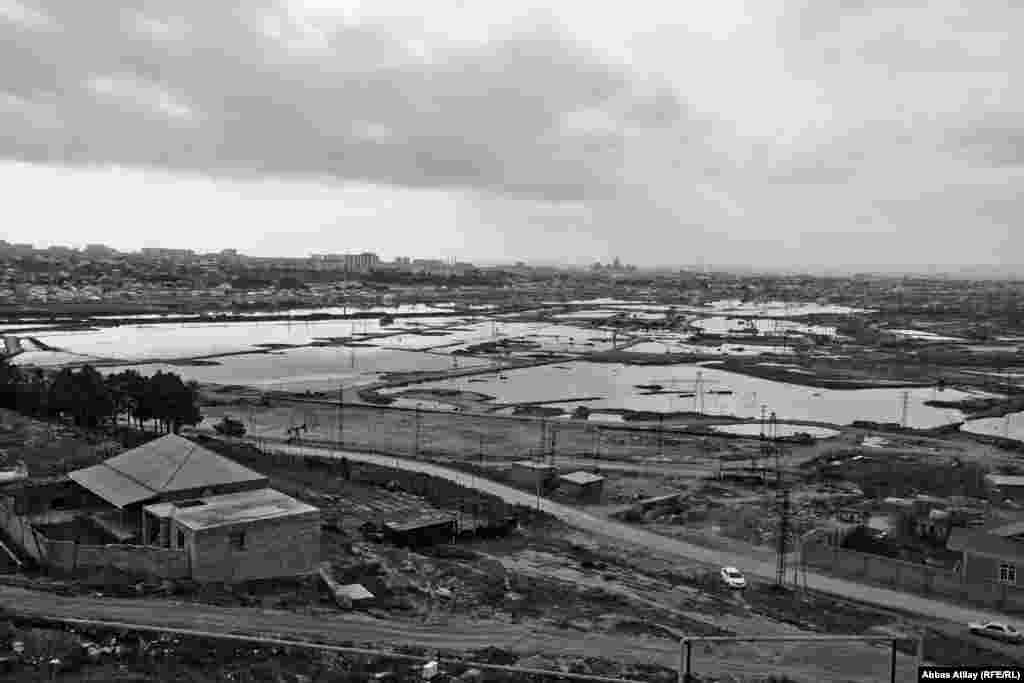 Neft gölməçələri və ətrafında tikilmiş evlər.