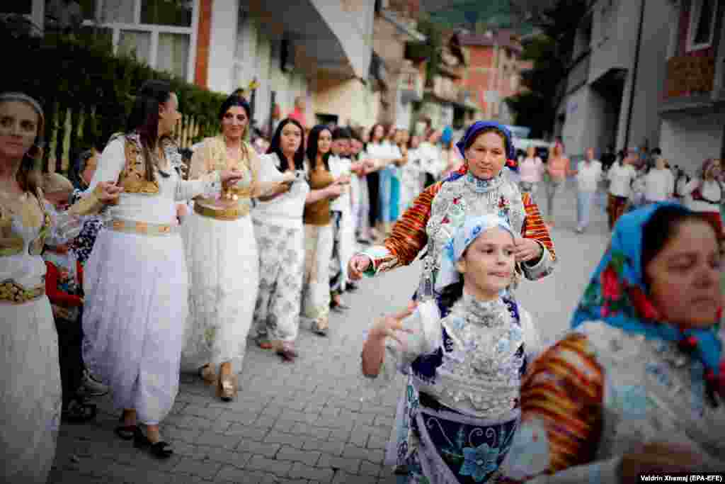 În timpul festivității, localnicele costumate în haine tradiționale dansează pe străzile satului.