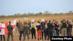 Участники митинга скромно держали плакаты в опущенных руках, пока осетинская журналистка, которой нужен был хоть один хороший кадр для своего агентства, жестами не попросила поднять их над головой