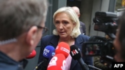 Președinta grupului parlamentar Rassemblement National, Marine Le Pen, se adresează presei la sosirea sa la sediul partidului său din Paris, pe 6 octombrie 2025.