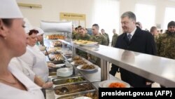 Ukrainian President Petro Poroshenko (right) queues for food with soldiers in the mess hall during his visit to the 95th Airborne Brigade in Zhytomyr on March 11.