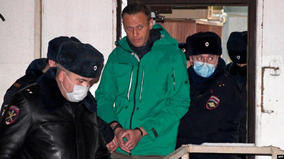 Aleksei Navalny is escorted out of a police station on January 18 in Khimki, outside Moscow.