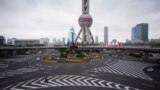 A police officer wears a mask as he walks in front of the Oriental Pearl Tower, as the country is hit by an outbreak of a new coronavirus, in Lujiazui financial district in Pudong, Shanghai, China, February 5, 2020.