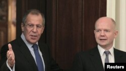 Foreign Minister Sergei Lavrov (L) shows the way to his British counterpart William Hague as they meet in Moscow