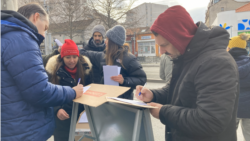 Građani potpisuju zahtev za vanrednim parlamentarnim izborima na jednom od štandova u Beogradu tokom akcije studenata u blokadi "Raspiši pobedu", 28 decembra 2025. 