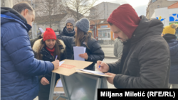 Građani potpisuju zahtev za vanrednim parlamentarnim izborima na jednom od štandova u Beogradu tokom akcije studenata u blokadi "Raspiši pobedu", 28 decembra 2025. 