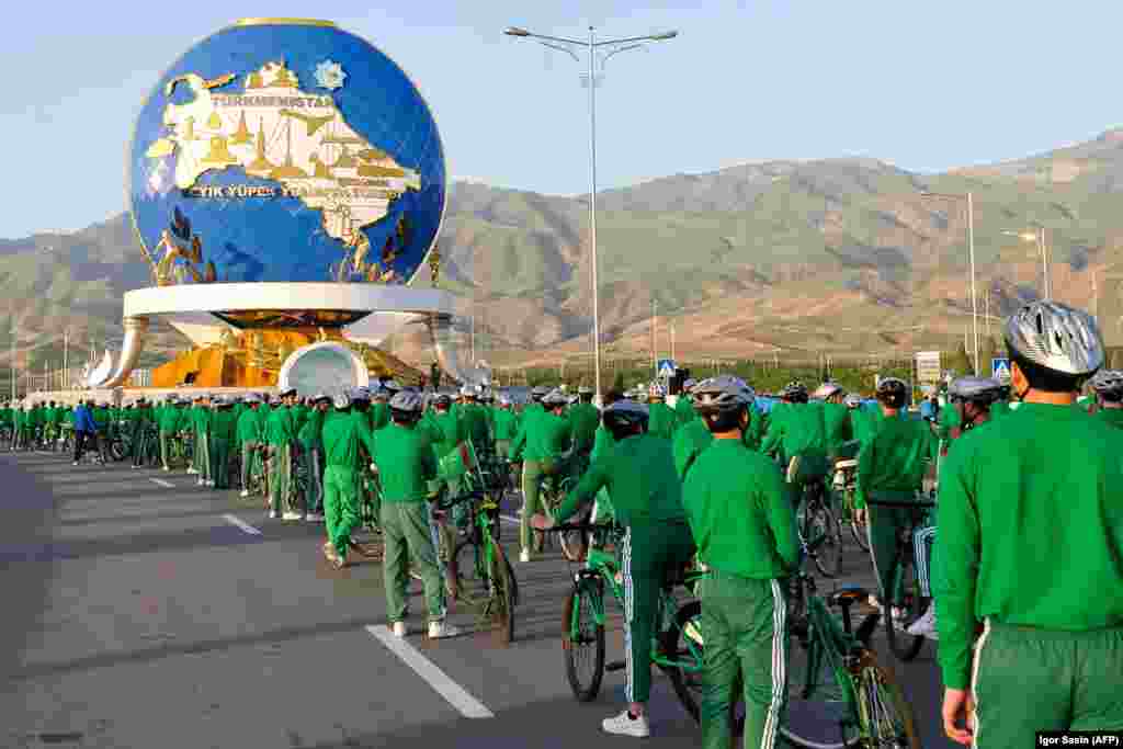 Cyclists stand in front of a 30-meter monument in Ashgabat honoring cycling, which has become an important component of state propaganda in Turkmenistan that promotes a healthy lifestyle. Thousands of tracksuit-wearing officials were brought along for a ride on June 3 as President Gurbanguly Berdymukhammedov spearheaded a parade to mark World Bicycle Day. (AFP/Igor Sasin)