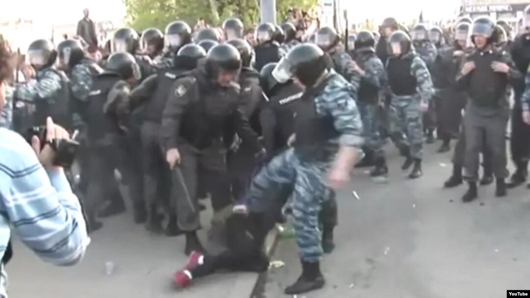 Кадр из видеоролика, на котором сотрудник ОМОНа бьет ногой женщину. 6 мая 2012 года
