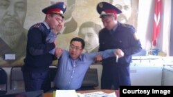 Полицейские задерживают Ермека Нарымбаева. Фото со страницы Андрея Цуканова в социальной сети Facebook. Алматы, 17 октября 2014 года. 
