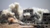 Smoke rises around buildings following a reported air strike on a rebel-held area in the southern Syrian city of Daraa on June 22.