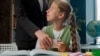 Confused Caucasian little girl child school kid pupil student schoolgirl playing mobile phone online game during lesson woman female strict teacher professor take away smartphone play inside classroom