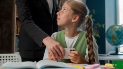 Confused Caucasian little girl child school kid pupil student schoolgirl playing mobile phone online game during lesson woman female strict teacher professor take away smartphone play inside classroom