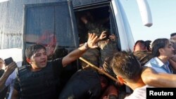 A policeman protects soldiers from the mob after troops involved in the coup surrendered on the Bosphorus Bridge in Istanbul, Turkey on July 16. 