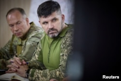 Nou numitul comandant, gen. de brigadă, Andrii Hnatov (dreapta), participă la o ședință cu președintele Zelenski în timpul vizitei pe linia frontului, la 26 iunie.