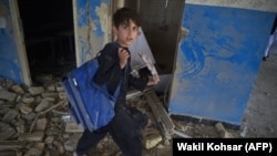 FILE: An Afghan school boy carries his backpack at a school near the site of a Taliban car bomb attack in Kabul in July 2.