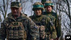 Ukrainian soldiers of the 28th Brigade walk together at their position on the front line near Bakhmut on March 27.